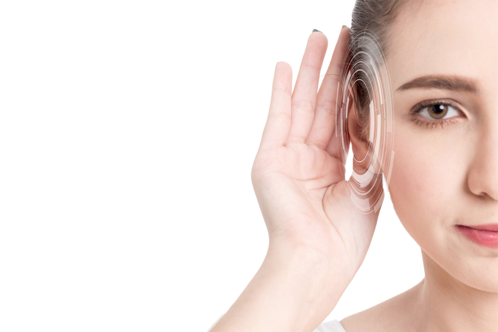 Woman cupping her ear to listen closely